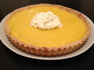 A homemade lemon curd tart with whipped cream topping